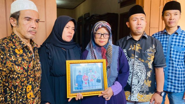 Keluarga kades Istri korban (memakai baju ungu) didampingi kerabat dan kuasa hukum memegang pigura foto Salamunasir, sang suami sekaligus Kades Curuggoong yang diduga dibunuh pada Minggu (12/3/2023). Foto: Nindia/ BantenNews.co.id