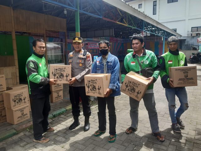Kapolres Pandeglang AKBP Belny Warlansyah secara simbolis menyerahkan paket sembako gratis untuk ojek online.