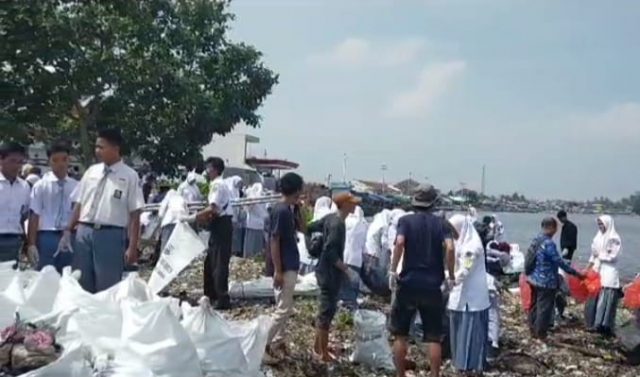 Ratusan warga hingga pelajar terjun ke lokasi membantu membersihkan tumpukan sampah di Desa Teluk, Kecamatan Labuan, Kabupaten Pandeglang.