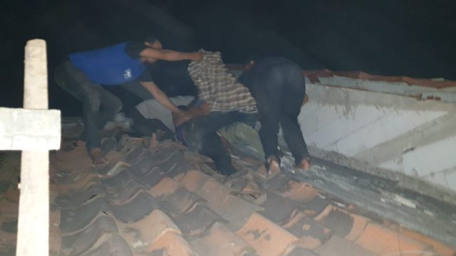 Warga mengevakuasi remaja yang akan lompat dari atap rumah.
