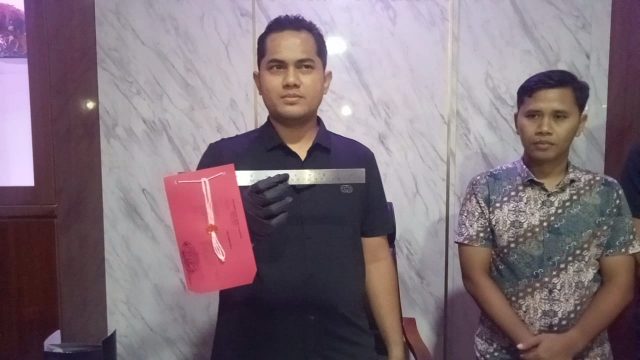 Kasatreskrim Polres Lebak saat memperlihatkan barang bukti berupa penggaris besi.
