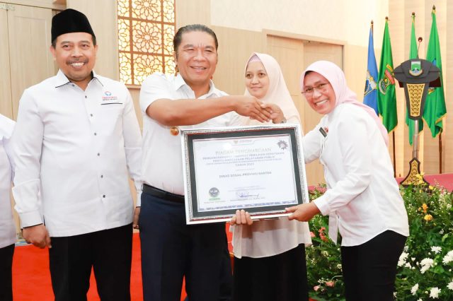 Pj Gubernur Banten Al Muktabar bersama Kepala Dinsos Banten Nurhana menerima penghargaan dari Ombudsman RI.